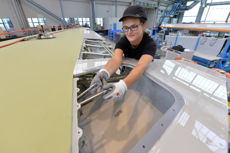 Eine Technikerin bei der Arbeit an einem Flugzeugflügel