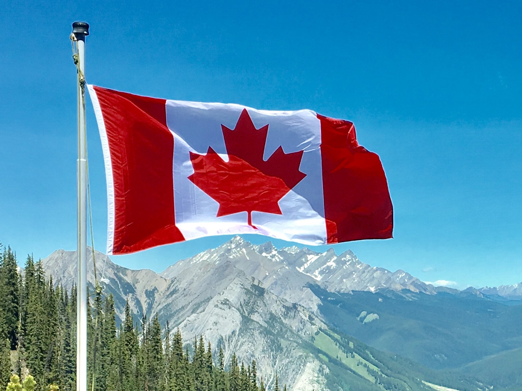 Die Kanadische Flagge vor einer Bergkulisse