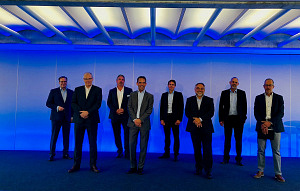 Gruppenbild von acht Männern, jeweils im Anzug