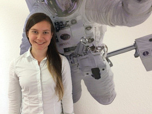 Eine Frau steht vor einem Bild, das einen Astronauten zeigt