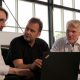 Drei Personen schauen in einen Laptop