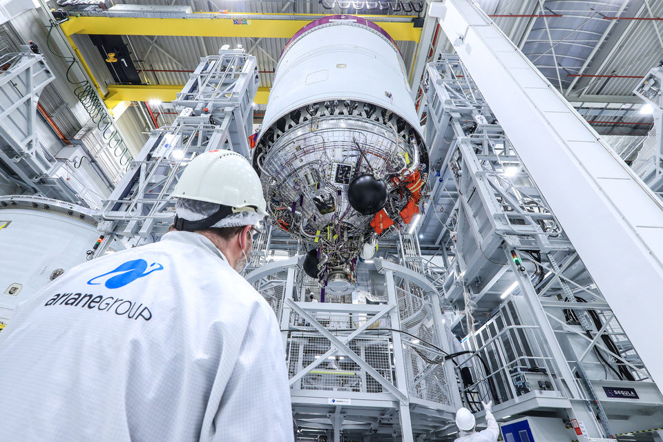 Eine Person schaut auf eine Raketenstufe im Werk