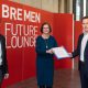 3 Personen vor rotem Hintergrund