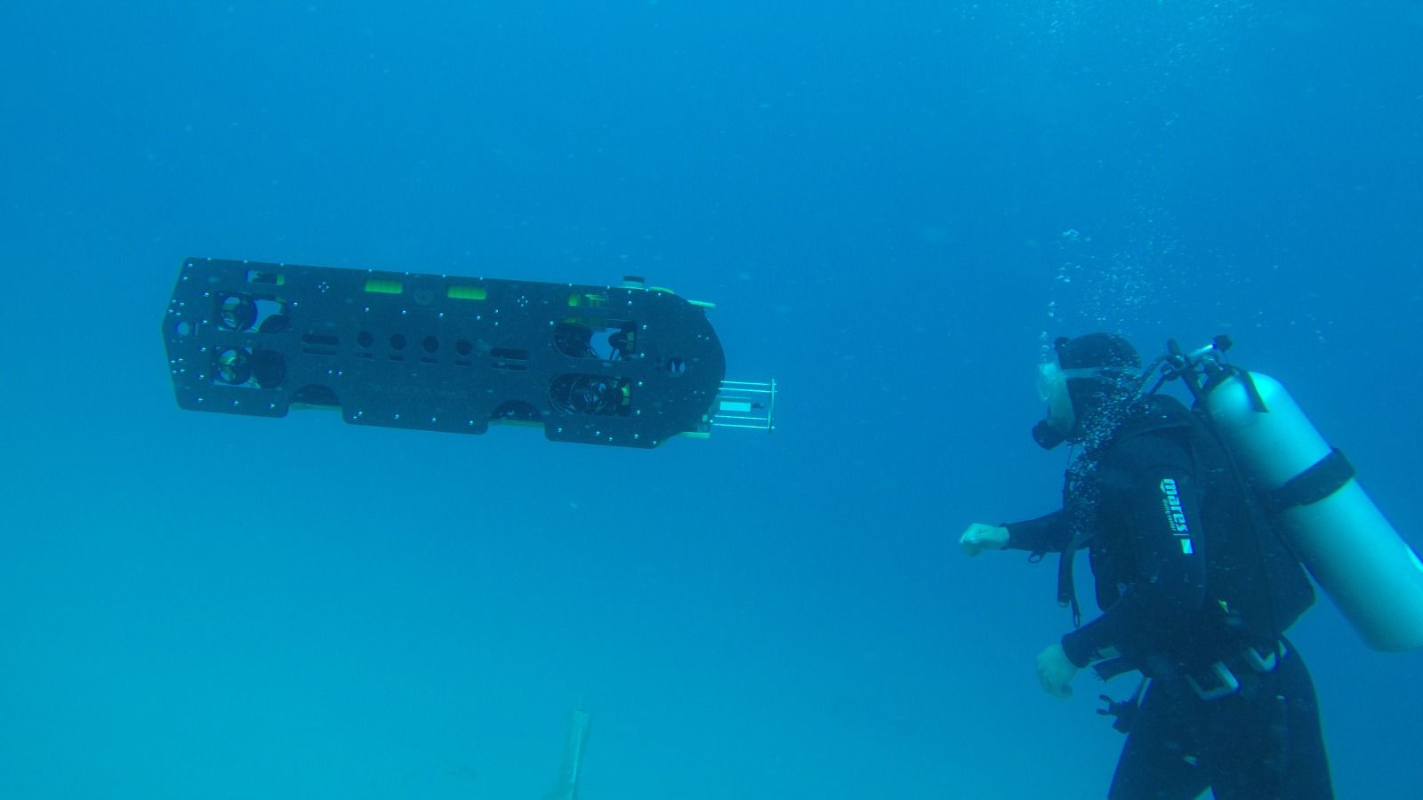 Diver under water with robot