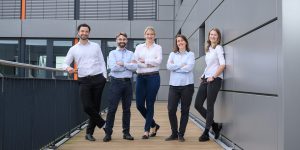 Fünf Personen auf einem Balkon zum Gruppenfoto.